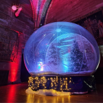 Giant Snow Globe lit up inside an indoor venue