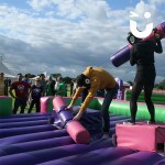 Guests watch and smiles as two people compete on the Gladiator Joust Hire