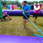 The pink team's keeper saving a shot from the blue team on the human table football