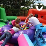 Family attempting to grab as many balls as possible on the Hungry Hippos Inflatable Hire