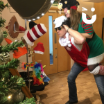Two people wearing Christmas outfits posing in front of our Magic Selfie Mirror
