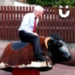 Old man in shirt and tie riding our Rodeo Bull Hire
