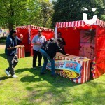 Coconut Shy Stall Hire being enjoyed by male colleagues in the sun at a staff event