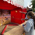 Coconut Shy Stall Hire at a community fun day being enjoyed by a father and daughter