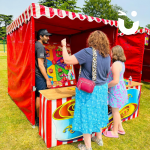 Mother and daughter having a go at the Ferris Wheel Hoopla Stall