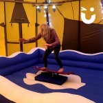 Women testing out our Snowboard Simulator Hire  during an indoor event