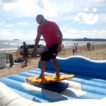 man on the surf simulator on the beach in the sun