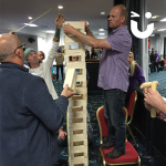 man building a tower with his team mates