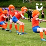 All dressed up in their funky outfits, challengers of a company team build begin to fall when competing in a Tug of War final