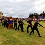 Joined by Sunshine Bear, a team of tuggers take their stance at a family fun day event in a Tug of War competition.