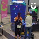 World's largest Pacman at an exhibition with 2 very happy ladies posing with 2 people competing