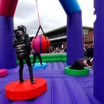 Children using the Wrecking Ball Inflatable on hire from Sunshine Events at a community Fun Day