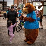 Fun Bear making friends in a town centre