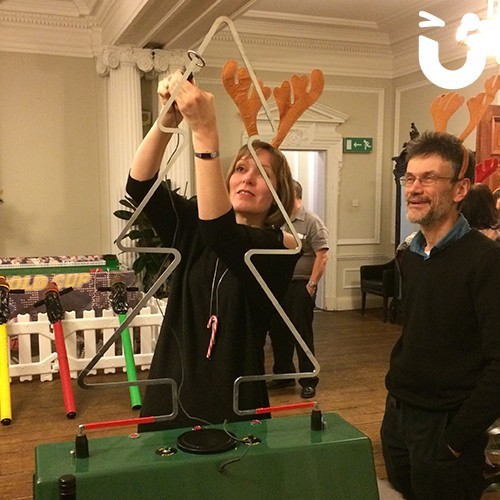 Two guest concentrrating on the Christmas buzz wire tree
