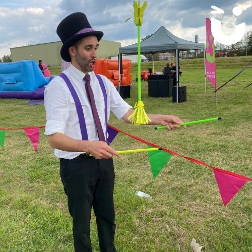 Circus Skills Workshop Hire with a professional in a top hat juggling neon sticks at a corporate fun day