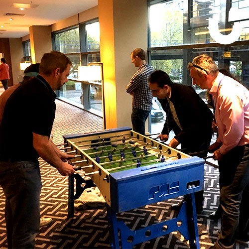 Group of men playing on the Our Table Football Hire