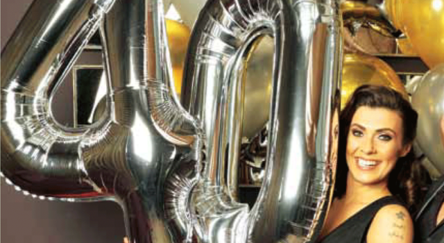 Kym Marsh posing with foil balloons shaped like the number 40