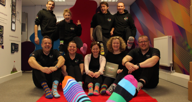 Fun Experts posing for a group photo with their odd socks for World Down Syndrome Day