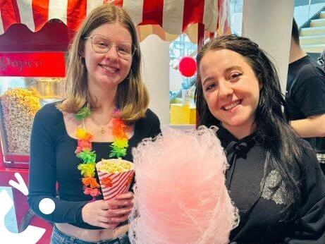 Candy Floss and Popcorn on the same cart with 2 young women enjoying their sweet treats
